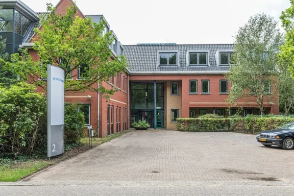 Kantoorgebouw aan de Laan Blussé van Oud-Alblas 2 met bakstenen gevel, grote ramen en entree in het midden.